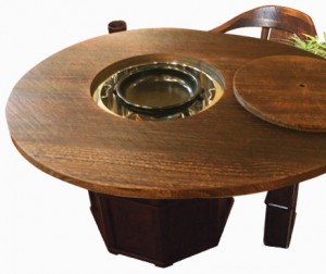 Egg-shaped IRORI dining table with wedge clamp made of Paulownia wood fired on surface